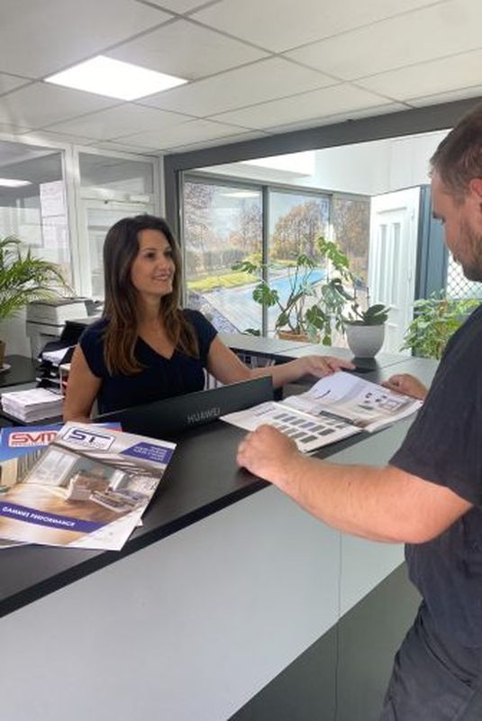 Un artisan se présente à l'accueil du groupe SVMFRANCE et est pris en charge par l'assistante administrative